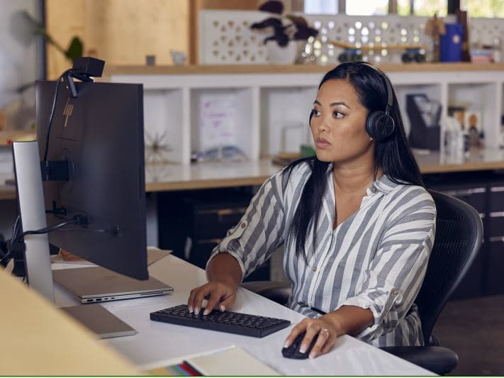 A person wearing headphones sitting at a desk